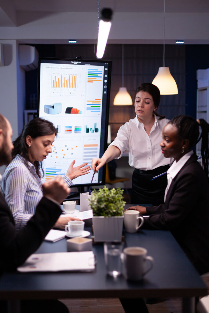 Multi-ethnic businesspeople discussing financial company solution sitting at conference table oxifix